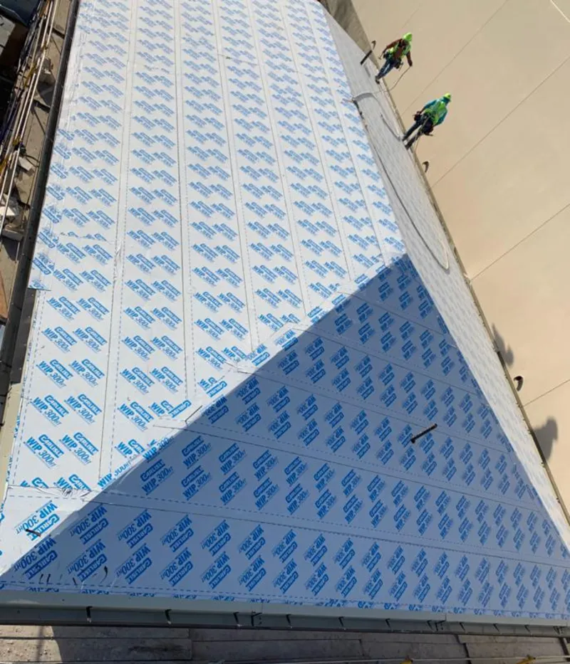 Professional roofers installing underlayment on a metal roof in Peoria Heights